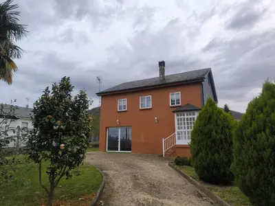 a red house with a car parked in front of it at Casa Sindo in Teixeira