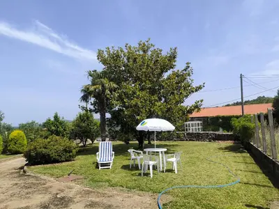 a red house with a white garage at Casa Sindo in Teixeira