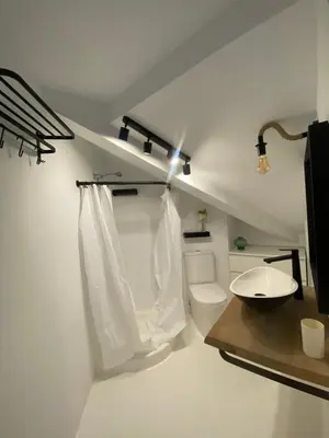 a white bathroom with a toilet and a sink at El ático de la terraza in Lugo