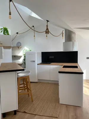 a kitchen with white counters and a white refrigerator at El ático de la terraza in Lugo