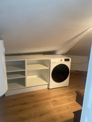 a washer and dryer sitting in the corner of a room at El ático de la terraza in Lugo