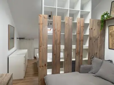 a room with a wooden partition with a couch at El ático de la terraza in Lugo