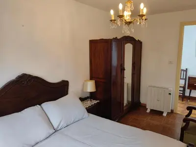 a bedroom with a bed and a chandelier at Casa rural con amplio terreno privado in Irijoa