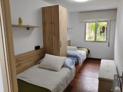 a row of beds in a room with a window at Casa rural con amplio terreno privado in Irijoa