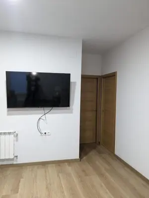 a white room with a flat screen tv on a wall at Pensión Castineiras in Sarria
