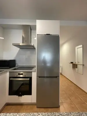 a kitchen with a stainless steel refrigerator and a stove at Apartamento a 400m de la playa en Ares, garaje incluído in Ares