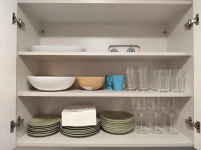 a cupboard with plates and dishes and glasses at Apartamento a 400m de la playa en Ares, garaje incluído in Ares