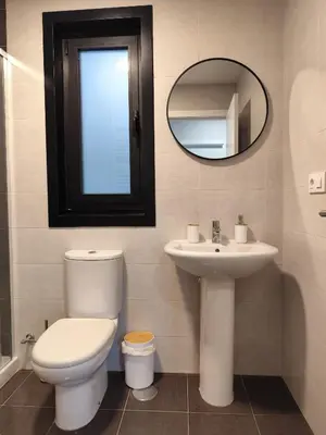 a bathroom with a toilet and a sink and a mirror at Apartamento a 400m de la playa en Ares, garaje incluído in Ares