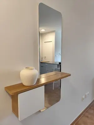 a mirror on a wall with a vase on a table at Apartamento a 400m de la playa en Ares, garaje incluído in Ares
