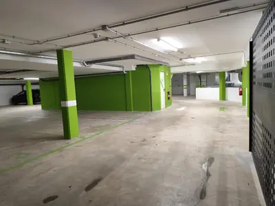 an empty parking garage with green columns in it at Apartamento a 400m de la playa en Ares, garaje incluído in Ares