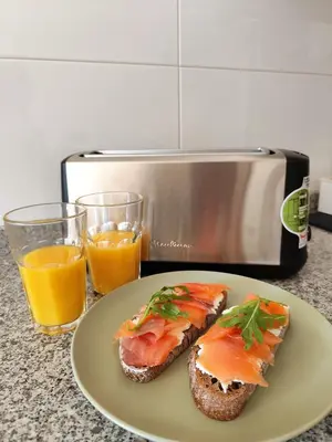 a plate with a sandwich and two glasses of orange juice at Apartamento a 400m de la playa en Ares, garaje incluído in Ares