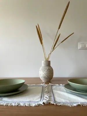 a table with two plates and a vase on it at Apartamento a 400m de la playa en Ares, garaje incluído in Ares