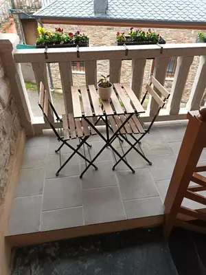 a table and chairs on a balcony with flowers at Él Rincón de los Sueños B in Vegadecabo