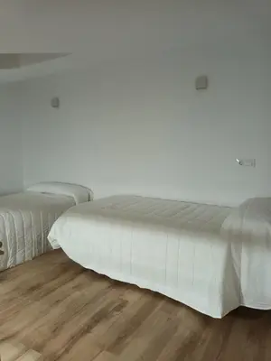 two beds sitting next to each other on a wooden floor at Él Rincón de los Sueños B in Vegadecabo