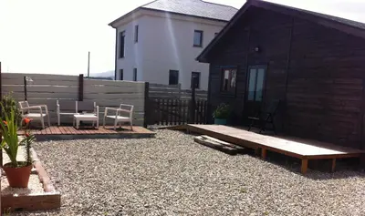a backyard with a bench and chairs and a building at Villas Eldorado-Mascotas Bienvenidas in Barreiros