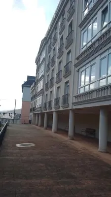a large white building with columns and windows at 2 habitaciones piscina y garage privado in Viveiro
