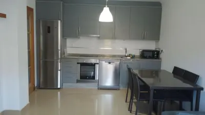 a kitchen with stainless steel appliances and a table at 2 habitaciones piscina y garage privado in Viveiro