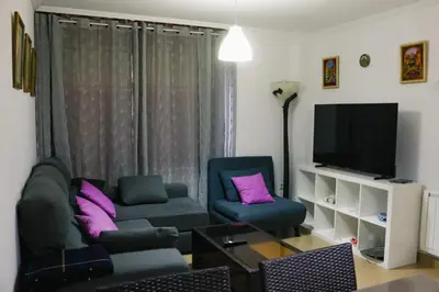 a living room with two chairs and a television at 2 habitaciones piscina y garage privado in Viveiro