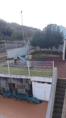 a fence with a playground in a park at 2 habitaciones piscina y garage privado in Viveiro