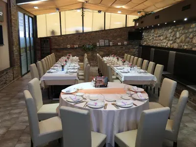 a long dining room with white tables and chairs at Hotel Calzada in Arcos