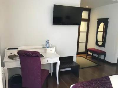 a bedroom with a desk and a tv on a wall at Hotel Calzada in Arcos