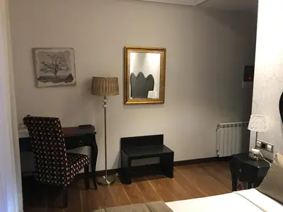 a bedroom with a desk and a chair and a mirror at Hotel Calzada in Arcos