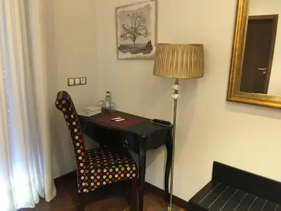 a desk with a chair and a lamp in a room at Hotel Calzada in Arcos