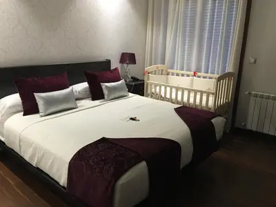 a bedroom with a large bed and a crib at Hotel Calzada in Arcos