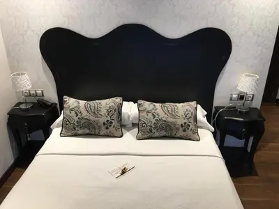 a bed with a black headboard and two night stands at Hotel Calzada in Arcos