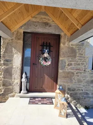 a front door of a stone building with a wreath on it at O Salgueiral Xove in Jove