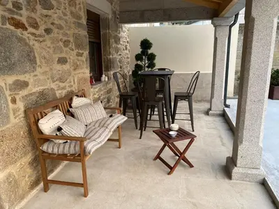 a patio with chairs and a table and a tableablish at O Salgueiral Xove in Jove