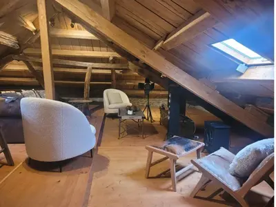 a attic room with a white chair and a couch at O Salgueiral Xove in Jove