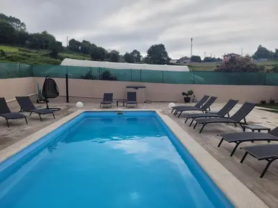 a swimming pool with lounge chairs and a table at O Salgueiral Xove in Jove