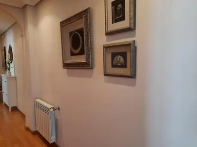 a hallway with framed pictures on the wall at Apartamento Camino de Santiago in Ordes