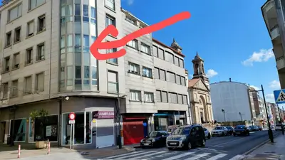 a building with a red sign on the side of it at Apartamento Camino de Santiago in Ordes
