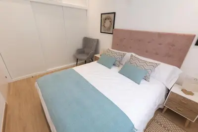 a bedroom with a large white bed with blue pillows at Camino Termal OURENSE in Valenzana