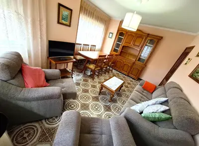a living room with two couches and a table at Apartamento Playa Foz 4 Dormitorios in Foz