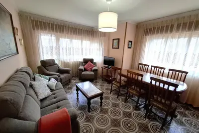 a living room with a couch and a dining room at Apartamento Playa Foz 4 Dormitorios in Foz