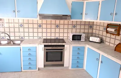 a kitchen with blue cabinets and a stove top oven at Apartamento Playa Foz 4 Dormitorios in Foz