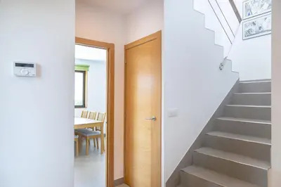 a hallway with a wooden door leading up to a stairs at Casa Folgoso in Santiago de Compostela