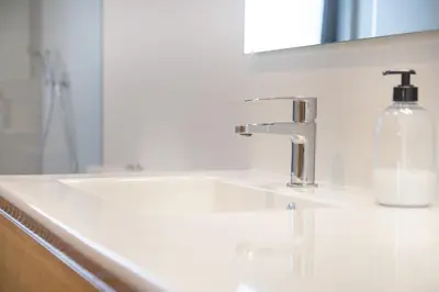 a white bathroom sink with a soap bottle on it at Casa Folgoso in Santiago de Compostela