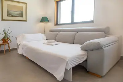 a living room with a bed and a couch at Casa Folgoso in Santiago de Compostela