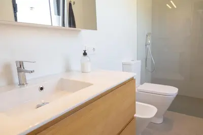 a white bathroom with a sink and a toilet at Casa Folgoso in Santiago de Compostela