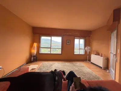 a living room with a couch and two windows at Hermosa casa en entorno termal in Pungín