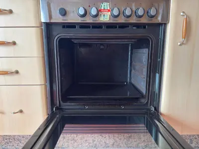 an oven in a kitchen with its door open at Hermosa casa en entorno termal in Pungín
