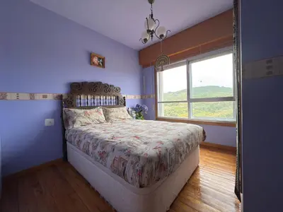 a bedroom with a bed and a large window at Hermosa casa en entorno termal in Pungín