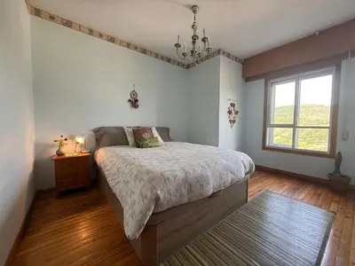 a bedroom with a large bed and a window at Hermosa casa en entorno termal in Pungín