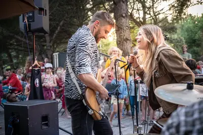 a man and a woman playing instruments at a concert at Huttopia Caminos de Galicia in Prado