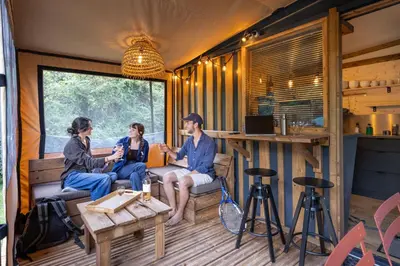 a group of people sitting in the inside of a caravan at Huttopia Caminos de Galicia in Prado
