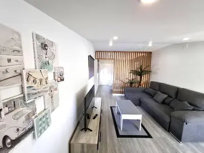 a living room with a couch and a table at Atico Deluxe Limosa romántico moderno junto al mar in San Ciprián